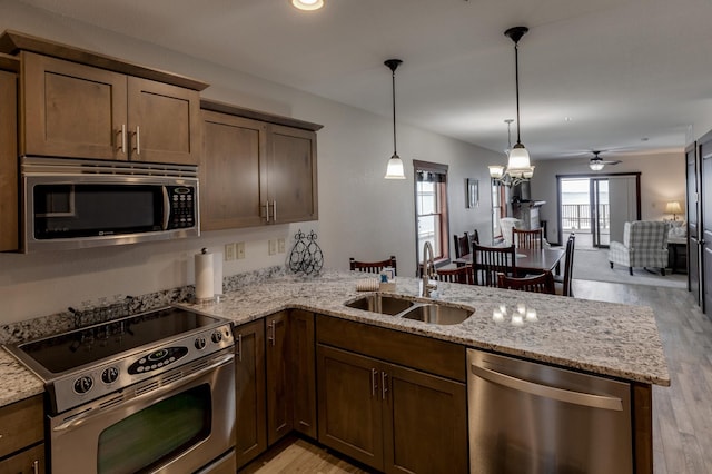 502 Cleveland Blvd Unit 3200, Walker, MN 56484 - kitchen with appliances with stainless steel finishes, a peninsula, light wood-style flooring, open floor plan, and light stone countertops