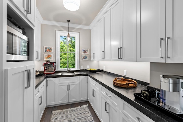 1595 Locust Hills Cir, Wayzata, MN 55391 - kitchen featuring stainless steel microwave, dark countertops, white cabinets, decorative light fixtures, and dark wood-style floors