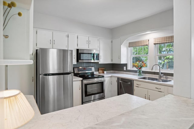 1511 Branston St, Saint Paul, MN 55108 - kitchen featuring appliances with stainless steel finishes, white cabinets, arched walkways, and backsplash