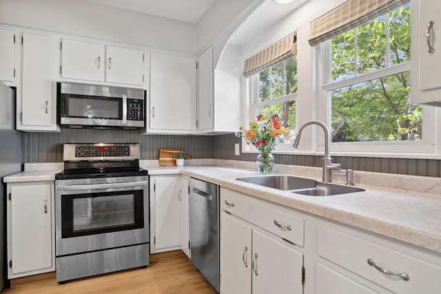 1511 Branston St, Saint Paul, MN 55108 - kitchen with stainless steel appliances, light countertops, white cabinets, and light wood-style flooring