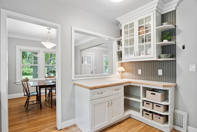 1511 Branston St, Saint Paul, MN 55108 - kitchen with open shelves, ornamental molding, white cabinetry, light wood-type flooring, and glass insert cabinets