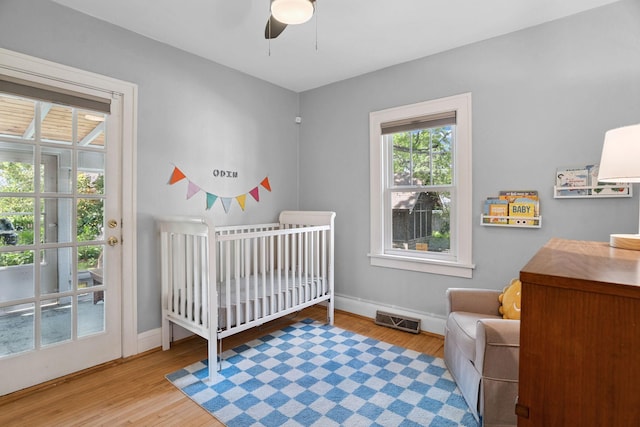 1511 Branston St, Saint Paul, MN 55108 - bedroom featuring wood finished floors, a crib, and a ceiling fan