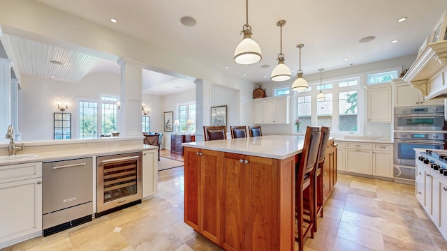 830 Prairie Island Rd N, Winona, MN 55987 - kitchen with wine cooler, stainless steel appliances, ornate columns, light countertops, and a warming drawer