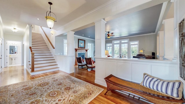 830 Prairie Island Rd N, Winona, MN 55987 - foyer entrance with decorative columns, light wood-style floors, stairway, ornamental molding, and a ceiling fan