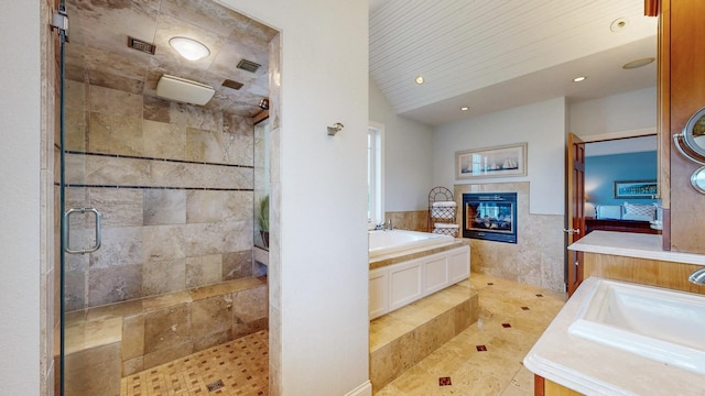 830 Prairie Island Rd N, Winona, MN 55987 - full bath with a tile fireplace, a garden tub, a shower stall, vanity, and recessed lighting