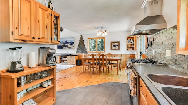 2756 7 5/8 Ave, Chetek, WI 54728 - kitchen with wall chimney exhaust hood, stainless steel gas range oven, a chandelier, open shelves, and glass insert cabinets