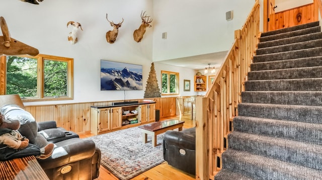 2756 7 5/8 Ave, Chetek, WI 54728 - living room with stairs, wood finished floors, wooden walls, a wainscoted wall, and a towering ceiling