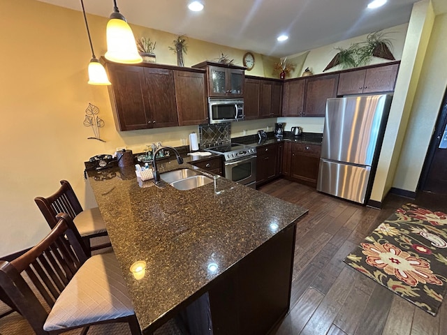502 Cleveland Blvd W Unit 2300, Walker, MN 56484 - kitchen with stainless steel appliances, dark wood finished floors, dark brown cabinetry, a peninsula, and dark stone counters