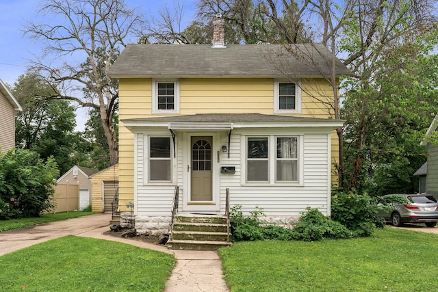 208 12th St SE, Austin, MN 55912 - american foursquare style home featuring roof with shingles, a front lawn, and a chimney