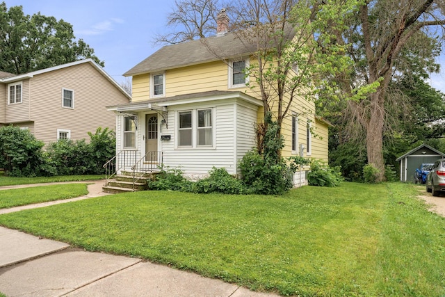 208 12th St SE, Austin, MN 55912 - view of front of house with a front lawn, a shed, and a chimney