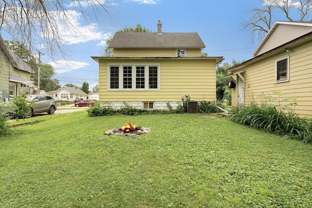 208 12th St SE, Austin, MN 55912 - back of house featuring a fire pit, a yard, and a chimney