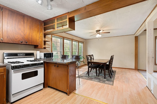 208 12th St SE, Austin, MN 55912 - kitchen featuring white appliances, open shelves, light wood-style flooring, brown cabinetry, and ceiling fan