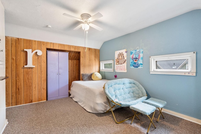 208 12th St SE, Austin, MN 55912 - carpeted bedroom with vaulted ceiling, wooden walls, and ceiling fan