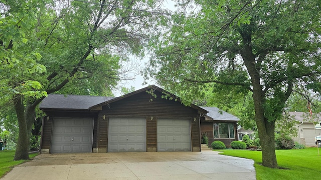 2145 Kenneth Dr, Albert Lea, MN 56007 - chalet / cabin featuring concrete driveway, a front yard, and a garage