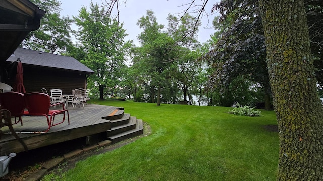2145 Kenneth Dr, Albert Lea, MN 56007 - view of grassy yard featuring outdoor dining space and a wooden deck