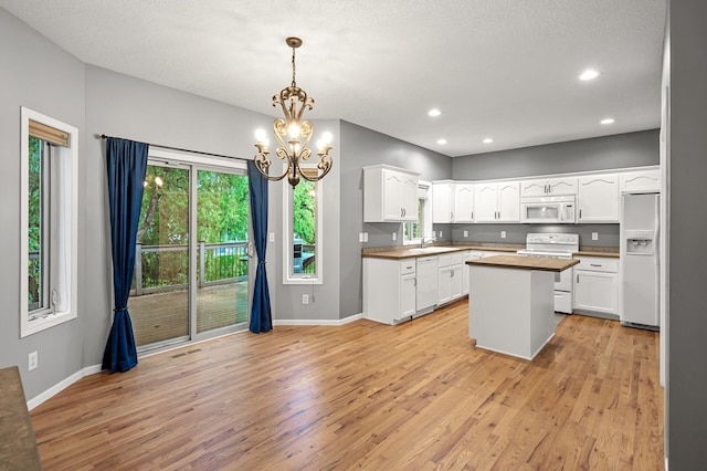 2403 Meadow Dr, Buffalo, MN 55313 - kitchen with white appliances, light wood-style flooring, a chandelier, white cabinetry, and recessed lighting