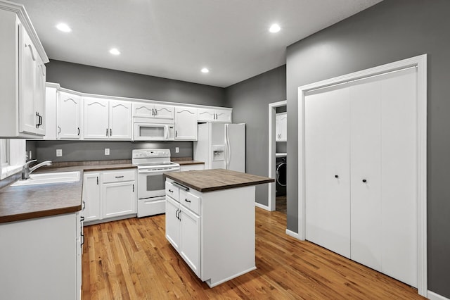 2403 Meadow Dr, Buffalo, MN 55313 - kitchen with white appliances, washer / clothes dryer, light wood-style flooring, white cabinets, and recessed lighting