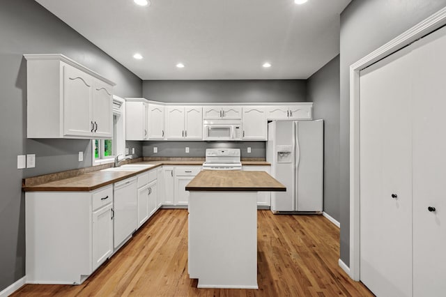 2403 Meadow Dr, Buffalo, MN 55313 - kitchen with white appliances, white cabinets, a center island, light wood-type flooring, and recessed lighting