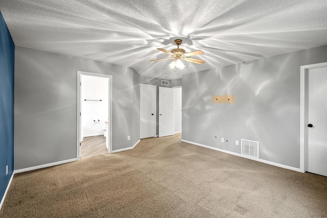2403 Meadow Dr, Buffalo, MN 55313 - unfurnished bedroom with carpet flooring, connected bathroom, a textured ceiling, and a ceiling fan