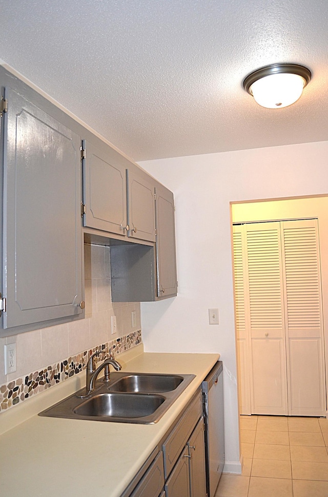 4387 Wilshire Blvd Unit 307, Mound, MN 55364 - kitchen with stainless steel dishwasher, gray cabinetry, light tile patterned floors, a textured ceiling, and light countertops
