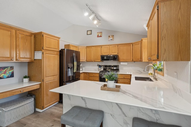 7175 Upper 157th St W, Apple Valley, MN 55124 - kitchen with appliances with stainless steel finishes, lofted ceiling, a peninsula, a kitchen breakfast bar, and light wood finished floors