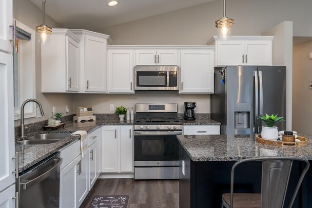 12 Kodiak Ct, North Mankato, MN 56003 - kitchen with appliances with stainless steel finishes, white cabinets, dark wood-type flooring, dark stone counters, and lofted ceiling