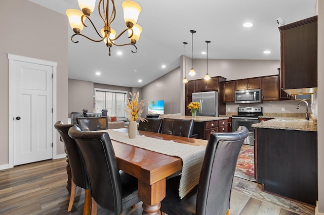 1226 1st St, Saint Paul Park, MN 55071 - dining area featuring wood finished floors, vaulted ceiling, and a chandelier