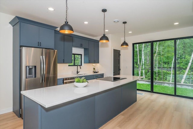 3733 London Rd Unit 15, Duluth, MN 55804 - kitchen featuring black electric cooktop, light countertops, light wood-style flooring, recessed lighting, and hanging light fixtures