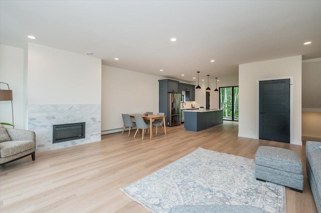 3733 London Rd Unit 15, Duluth, MN 55804 - living room featuring light wood finished floors, a fireplace, a baseboard radiator, and recessed lighting