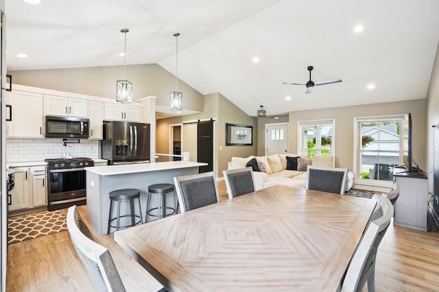 1623 Otter Way, New Richmond, WI 54017 - dining area featuring a barn door, a ceiling fan, vaulted ceiling, light wood-style flooring, and recessed lighting