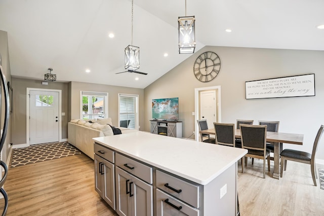 1623 Otter Way, New Richmond, WI 54017 - kitchen with gray cabinets, vaulted ceiling, light wood-style flooring, light countertops, and a kitchen island