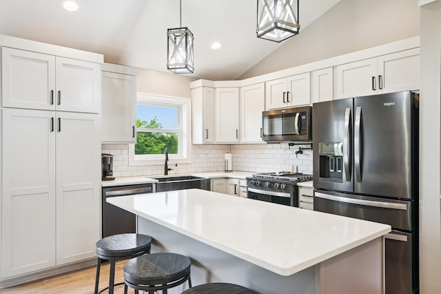 1623 Otter Way, New Richmond, WI 54017 - kitchen with stainless steel appliances, lofted ceiling, a kitchen breakfast bar, light countertops, and backsplash