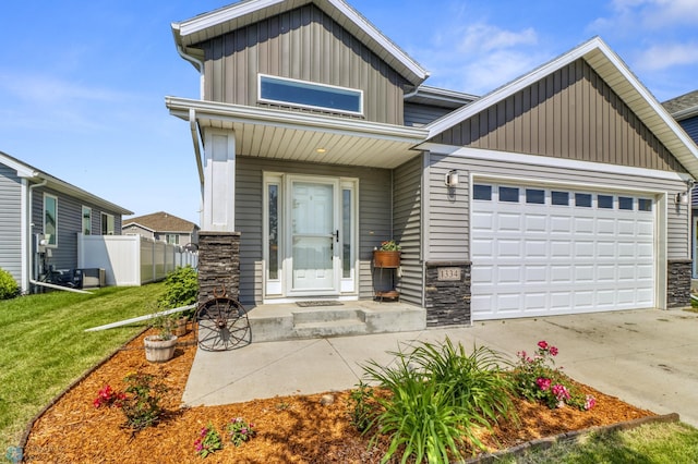 1334 6th St NW, Fargo, ND 58078 - view of front of home featuring an attached garage, stone siding, concrete driveway, and board and batten siding