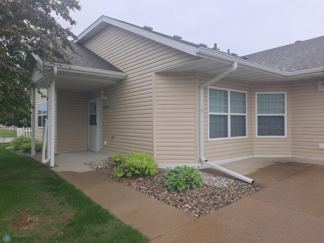 5409 University Dr S Unit D, Fargo, ND 58104 - doorway to property featuring roof with shingles and a patio area