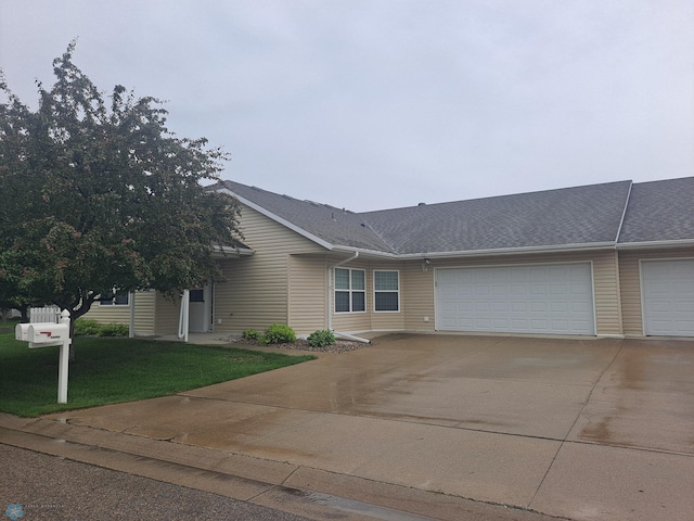 5409 University Dr S Unit D, Fargo, ND 58104 - view of front facade featuring concrete driveway, an attached garage, roof with shingles, and a front yard