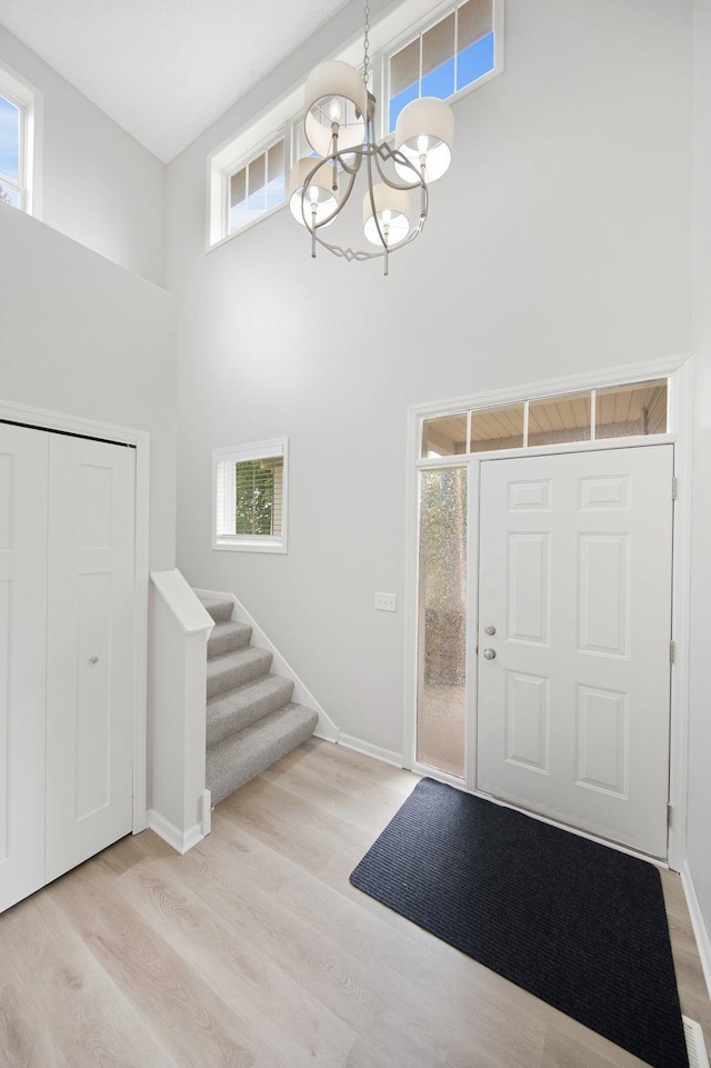 6758 Troy Ln N, Maple Grove, MN 55311 - entryway with a high ceiling, a chandelier, light wood-style flooring, and stairs