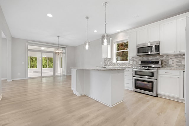 6758 Troy Ln N, Maple Grove, MN 55311 - kitchen with appliances with stainless steel finishes, tasteful backsplash, light wood-style flooring, a center island, and white cabinets