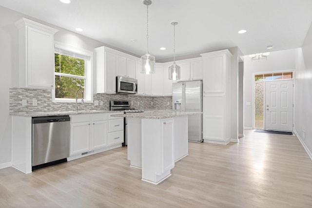 6758 Troy Ln N, Maple Grove, MN 55311 - kitchen featuring stainless steel appliances, light wood-type flooring, backsplash, white cabinetry, and a center island