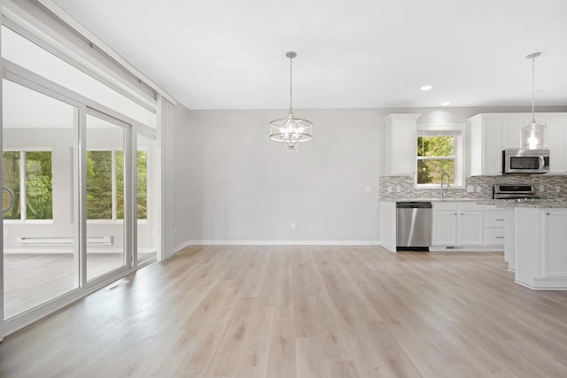 6758 Troy Ln N, Maple Grove, MN 55311 - kitchen with appliances with stainless steel finishes, decorative backsplash, light wood-type flooring, a chandelier, and white cabinetry