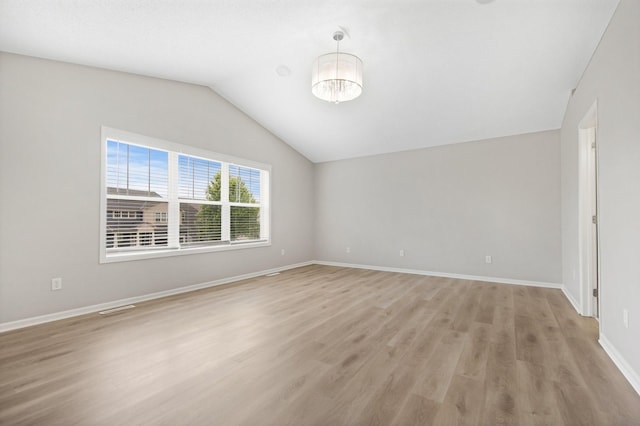 6758 Troy Ln N, Maple Grove, MN 55311 - empty room with light wood-style flooring, vaulted ceiling, and a chandelier