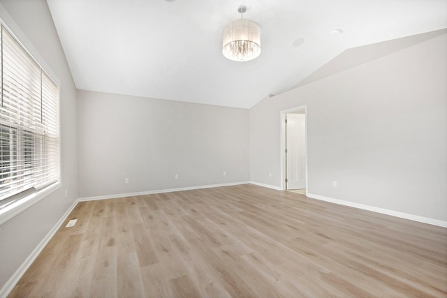 6758 Troy Ln N, Maple Grove, MN 55311 - unfurnished room featuring vaulted ceiling, light wood-style floors, and a chandelier