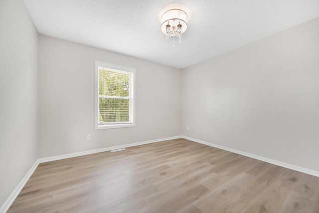 6758 Troy Ln N, Maple Grove, MN 55311 - spare room with light wood-style floors and a chandelier