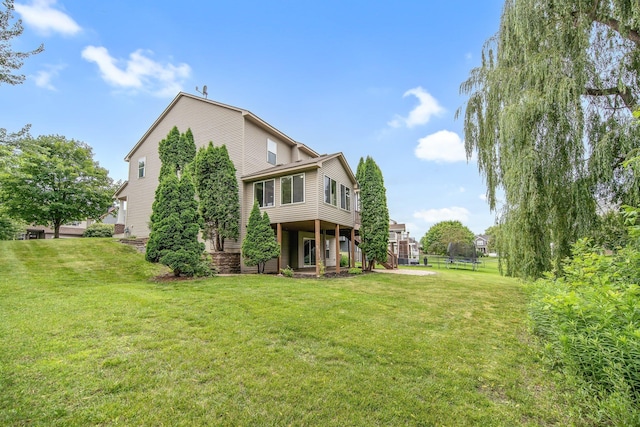 6758 Troy Ln N, Maple Grove, MN 55311 - rear view of house with a trampoline and a yard