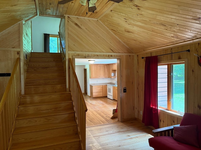 43564 Tamarack River Rd, Ogema Twp, MN 55037 - stairs with vaulted ceiling, wooden ceiling, wooden walls, hardwood / wood-style flooring, and ceiling fan