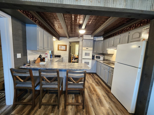 207 Mill Rd, Park Rapids, MN 56470 - kitchen featuring white appliances, dark wood finished floors, a peninsula, and gray cabinets
