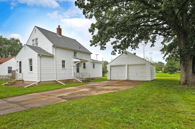 913 12th Ave SE, Austin, MN 55912 - back of house featuring an outbuilding, a detached garage, a chimney, a shingled roof, and a yard