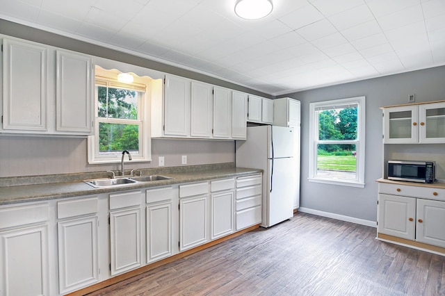 913 12th Ave SE, Austin, MN 55912 - kitchen featuring freestanding refrigerator, stainless steel microwave, light wood-style floors, and white cabinets