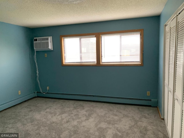 7236 72nd Ln N Unit 202, Brooklyn Park, MN 55428 - unfurnished bedroom featuring carpet floors, a wall mounted air conditioner, a baseboard radiator, a textured ceiling, and a closet