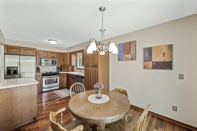4133 88th Ave NE, Blaine, MN 55014 - dining room featuring a chandelier, dark wood-style flooring, and a textured ceiling