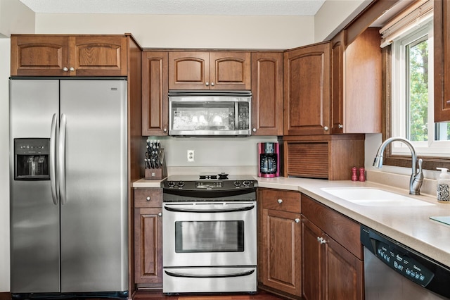 4133 88th Ave NE, Blaine, MN 55014 - kitchen featuring appliances with stainless steel finishes, plenty of natural light, brown cabinets, and light countertops
